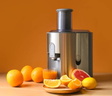 Yeni modern meyve sıkacağı ve bir bardak taze meyve suyu.