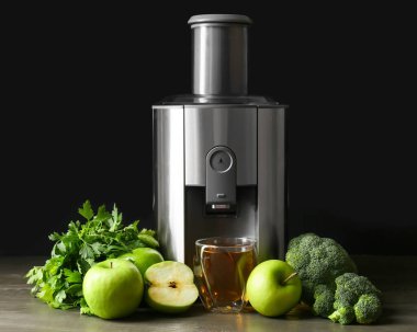 Yeni modern meyve sıkacağı ve bir bardak taze meyve suyu.