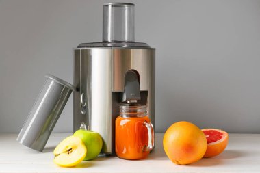 Yeni modern meyve sıkacağı ve bir kavanoz taze meyve suyu.