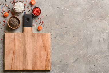 Gri arkaplanda yeni kesim tahtası ve baharatlar