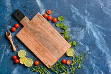 Mavi arka planda domatesli ve limonlu yeni kesim tahtası