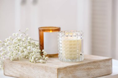 Masada yanan mumlar ve çiçekler olan tutucular, yakın plan.