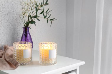 Mumları tutacaklarda ve vazolarda yakıyorum. Masada çiçekler var.