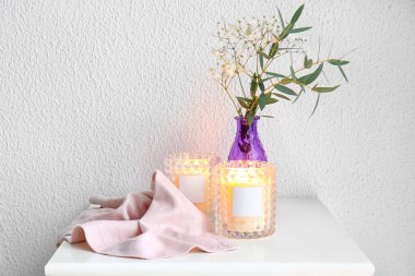 Mumları tutacaklarda ve vazolarda yakıyorum. Masada çiçekler var.