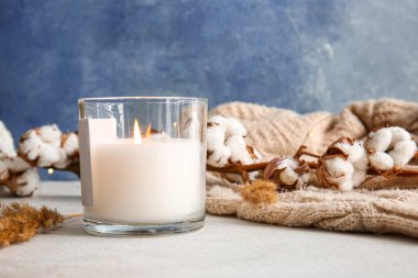 Masada yanan mum ve pamuk dalı olan tutucu, yakın plan.