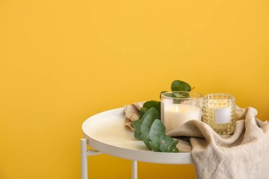 Masada yanan mumlar ve okaliptüs dalı olan tutucular