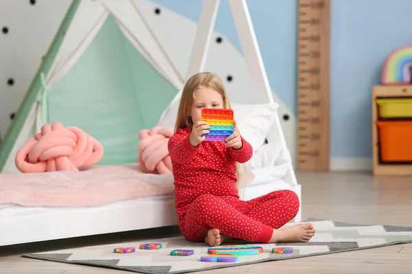 Little Girl Sitting Floor Holding Multicolored Pop Fidget Toy Child — Stock Fotó
