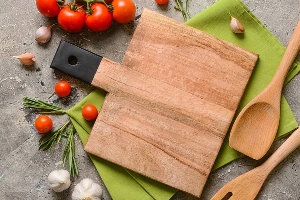 Gri arka planda baharat ve domatesli yeni kesim tahtası
