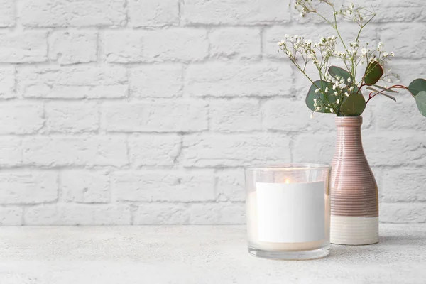 Cam tutacağı, yanan mum ve ışık masasında çiçekler.