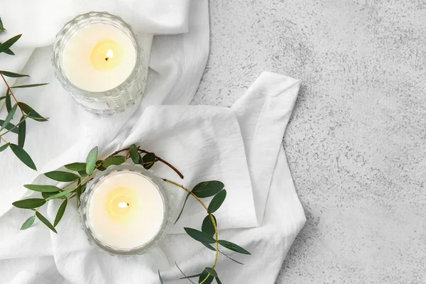 Yanan mumları ve okaliptüs dalları olan cam tutucular.