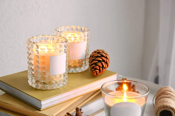Holders Burning Candles Books Pine Cones Table Closeup — Stok fotoğraf