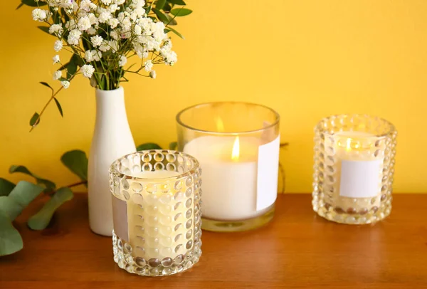 Κάτοχοι Αναμμένα Κεριά Και Λουλούδια Ξύλινο Τραπέζι Closeup — Φωτογραφία Αρχείου