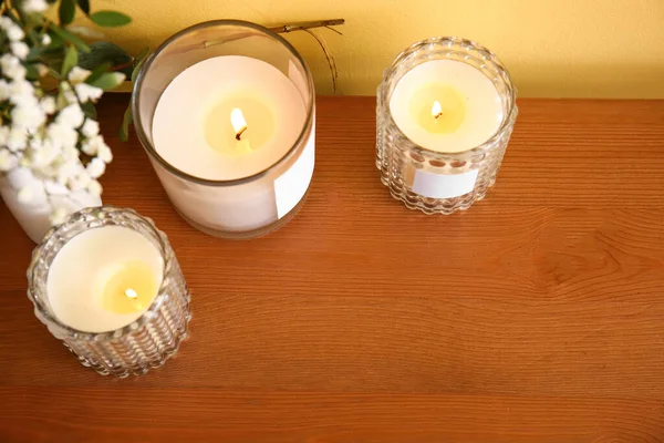 Halter Mit Brennenden Kerzen Und Blumen Auf Holztisch Nahaufnahme — Stockfoto