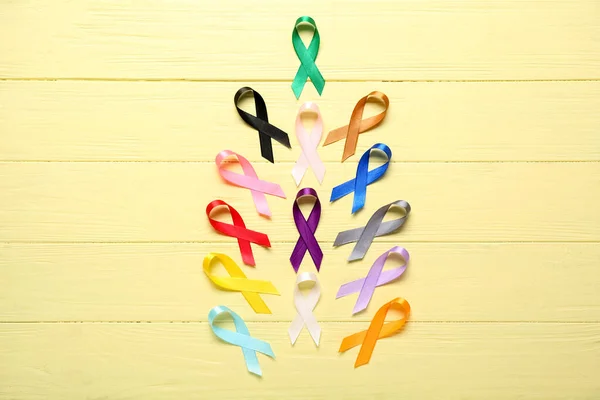 Kompozice Známými Stuhami Žlutém Dřevěném Podkladu Světový Den Rakoviny — Stock fotografie