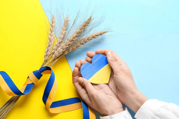 Ukrayna bayrağı, dikenler ve sarı ve mavi arka planda kurdele renginde kalbi olan eller.