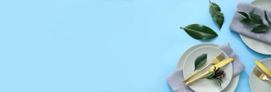 Açık mavi arkaplan üzerinde yeşil yapraklar ile zarif tablo ayarı metin için boşluk