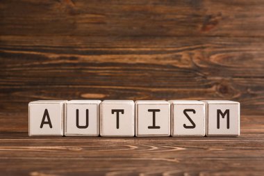 Sözcük AUTISM tahtadan arkaplandaki küplerden oluşur