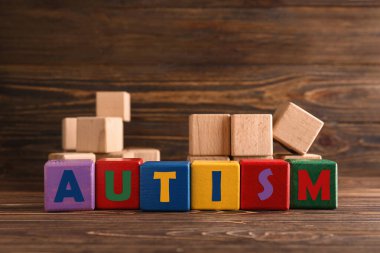 Sözcük AUTISM tahtadan arkaplandaki küplerden oluşur