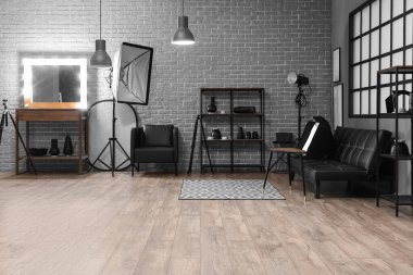 Rafların, aynanın ve profesyonel ekipmanların bulunduğu modern fotoğraf stüdyosunun içi