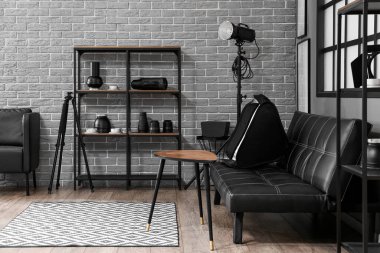 Raflar, kanepe ve profesyonel ekipmanlarla modern fotoğraf stüdyosunun içinde.