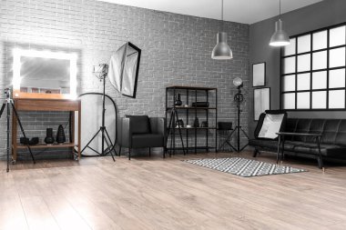 Raflar, ayna ve profesyonel ekipmanlarla modern fotoğraf stüdyosunun içinde.