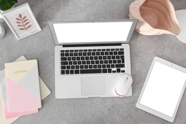 Not defterleri, modern dizüstü bilgisayar ve tablet bilgisayar gri masada.