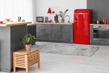 Kırmızı buzdolabı, tezgah ve tahta kaplı modern mutfak.