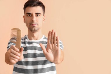 Taraklı yakışıklı adam bej arka planda dur işareti yapıyor