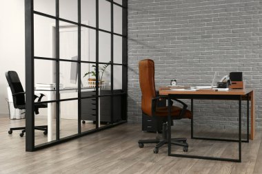 Ofisin içindeki gri tuğla duvarın yanındaki işyerinde.