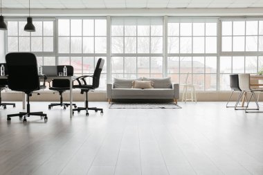 Koltuğu, masası ve sandalyeleri olan ışık ofisinin içinde.