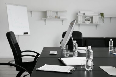 Modern bilgisayarlı masa ve konferans odasında bir şişe su.