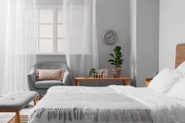 Rahat bir yatak ve şık bir saat. Odadaki ışık duvarında.