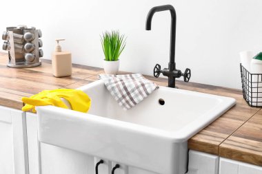 Beyaz duvarın yanında lastik eldivenli modern lavabo.