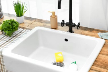 Mutfakta bulaşık yıkamak için süngerli modern lavabo.