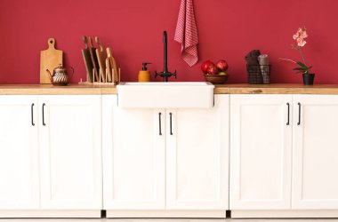 Farklı mutfak aletleri ve modern lavaboları olan tezgahlar şık mutfak duvarlarının yanında.