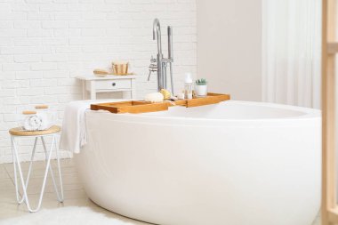 Banyo içi ahşap tepsi ve farklı malzemelerle modern banyo küveti.