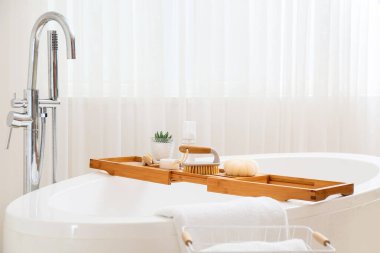 Banyoda vücut masajı fırçaları ve kozmetik ürünleri olan küvet tepsisi.