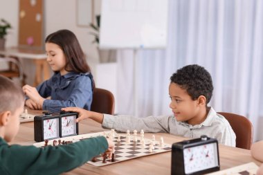 Kulüpte turnuvada satranç oynayan küçük çocuklar.