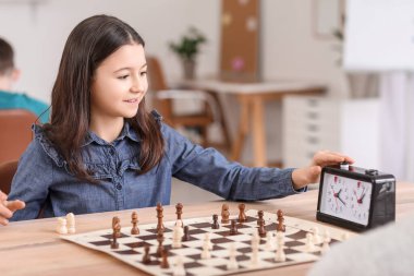 Kulüpte turnuvada satranç oynayan küçük kız.