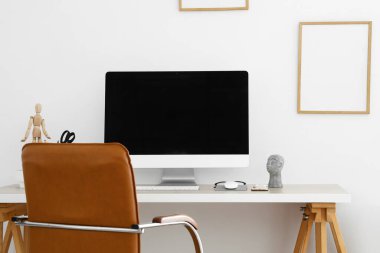 Modern bilgisayar beyaz duvarın yanındaki masada