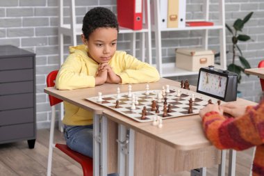 Kulüpte turnuvada satranç oynayan küçük çocuklar.