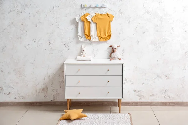Aydınlık Duvarda Oyuncak Bebek Kıyafetleri Asılı Çekmeceler — Stok fotoğraf