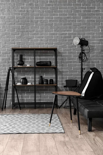 Raflar, kanepe ve profesyonel ekipmanlarla modern fotoğraf stüdyosunun içinde.