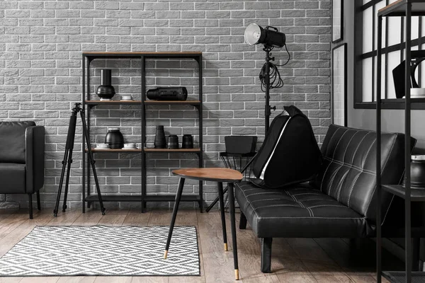 Raflar, kanepe ve profesyonel ekipmanlarla modern fotoğraf stüdyosunun içinde.