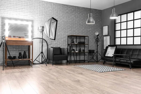 Raflar, ayna ve profesyonel ekipmanlarla modern fotoğraf stüdyosunun içinde.