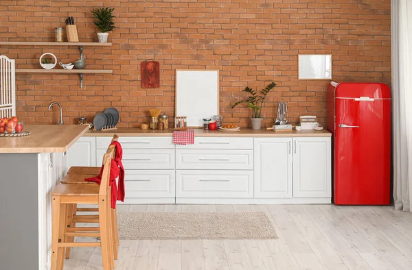 Modern mutfak, yemek masası, tezgah ve şık buzdolabı.