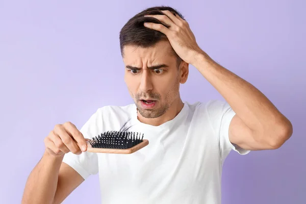 Jovem Preocupado Segurando Escova Com Cabelo Caído Fundo Lilás — Fotografia de Stock