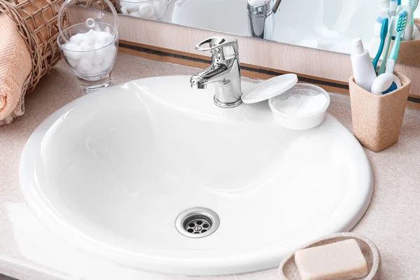 现代洗碗池和不同的洗浴用品放在桌上 — 图库照片