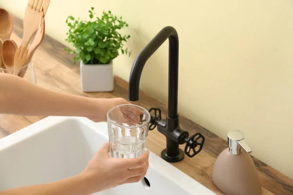 Woman Pouring Water Faucet Glass Color Wall Closeup — стоковое фото