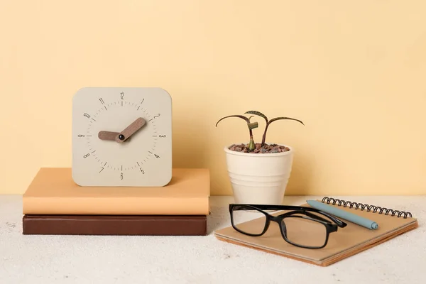 Alarm Clock Stack Books Eyeglasses Houseplant Table Color Wall — Stock Photo, Image